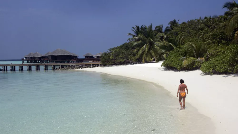 Renate Reinstaller, a tourist from Meran, Italy, walks a beach at the Baros Resort Island in the Maldives Saturday, Jan. 15, 2005. With French charter flights likely to resume soon and Italy lifting a warning against travel to the Indian Ocean archipelago, authorities are hoping that the balm of tourism would ease the impact of the Dec. 26 tsunami on Maldives. (AP Photo/Ed Wray)
