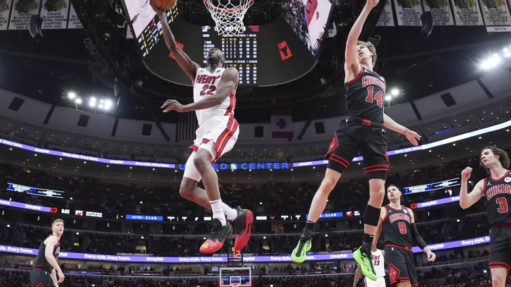 Miami Heat forward Andrew Wiggins, left, drives to the basket past Chicago Bulls forward Matas Buzelis during the first half of an NBA play-in tournament basketball game in Chicago, Wednesday, April 16, 2025. (AP Photo/Nam Y. Huh)
