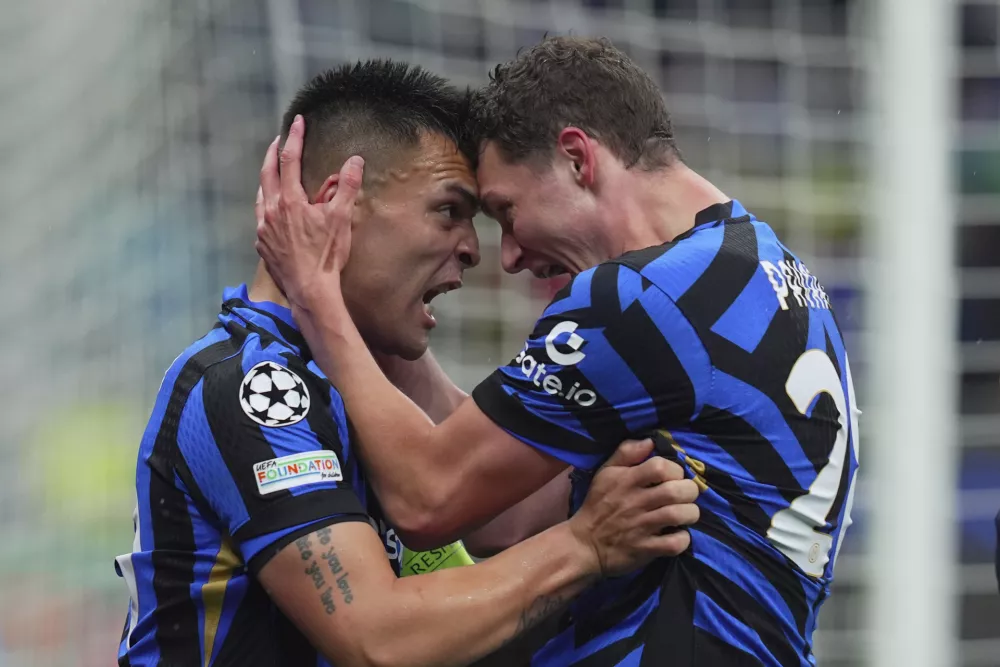 Inter Milan's Lautaro Martinez celebrates after scoring with teammate Benjamin Pavard, right, during the Champions League quarter final soccer match between Inter Milan and Bayern Munich at San Siro Stadium in Milan, North Italy, Wednesday April 16, 2025. (Spada/LaPresse via AP)