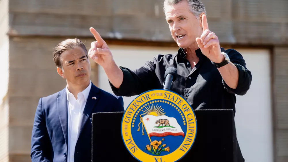 California Gov. Gavin Newsom discusses President Donald Trump's tariffs, as California Attorney General Rob Bonta, left, listens, during a press conference on Wednesday, April 16, 2025, at an almond farm in Ceres, Calif. (AP Photo/Noah Berger)