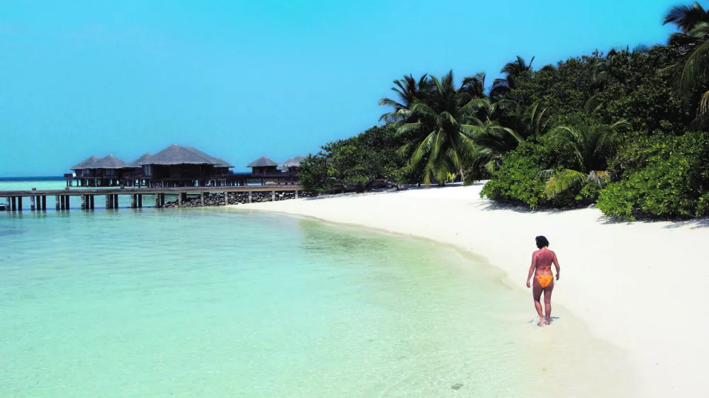 Renate Reinstaller, a tourist from Meran, Italy, walks a beach at the Baros Resort Island in the Maldives Saturday, Jan. 15, 2005. With French charter flights likely to resume soon and Italy lifting a warning against travel to the Indian Ocean archipelago, authorities are hoping that the balm of tourism would ease the impact of the Dec. 26 tsunami on Maldives. (AP Photo/Ed Wray)------3k