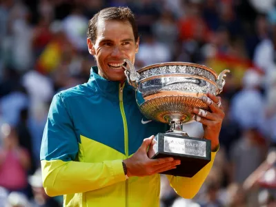 FILE PHOTO: Tennis - French Open - Roland Garros, Paris, France - June 5, 2022 Spain's Rafael Nadal bites the trophy to celebrate winning the men's singles final against Norway's Casper Ruud REUTERS/Yves Herman/File Photo