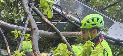 In this photo released by the Italian Alpine and Speleological Rescue Corps on Thursday, April 17, 2025, rescuers reach for the smashed gondola of the Mt. Faito cable car near Naples in southern Italy.