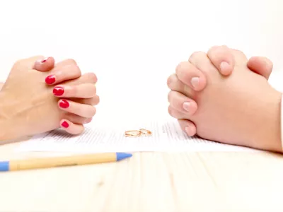 Closeup of a young man an a young woman signing a prenuptial agreement