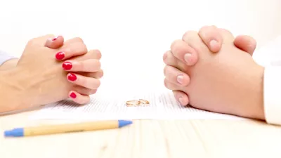 Closeup of a young man an a young woman signing a prenuptial agreement
