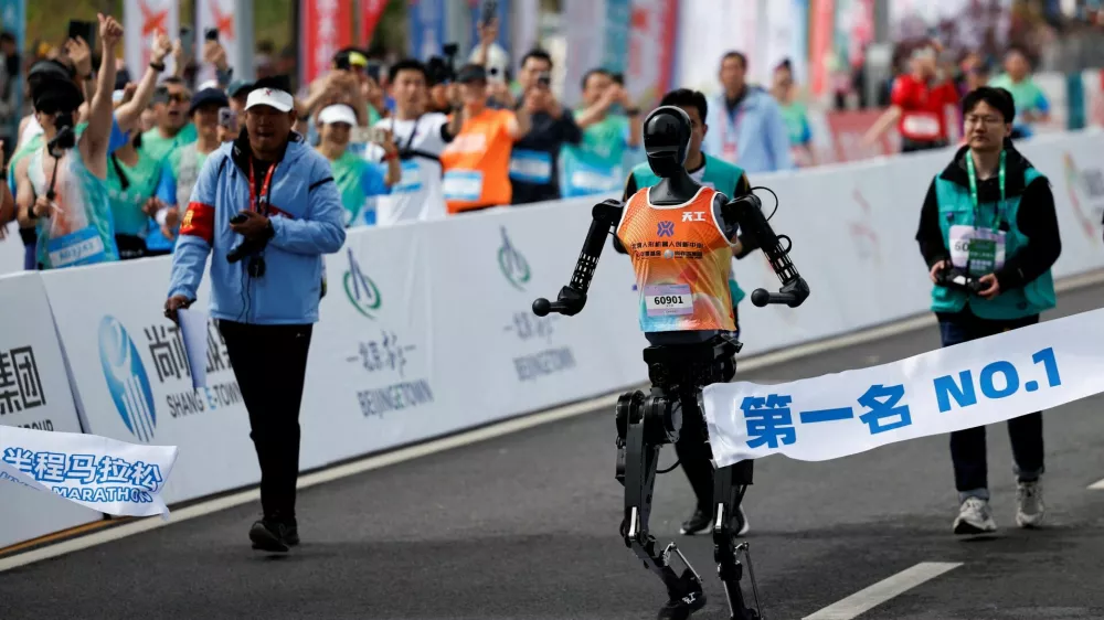 Tiangong Ultra, a humanoid robot runs across the finish line while securing the first position during the E-Town Humanoid Robot Half Marathon, in Beijing, China April 19, 2025. REUTERS/Tingshu Wang