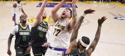 Los Angeles Lakers guard Luka Doncic (77) shoots as Minnesota Timberwolves guard Nickeil Alexander-Walker (9), guard Donte DiVincenzo (0) and center Naz Reid (11) defend during the second half in Game 1 of an NBA first-round playoff series Saturday, April 19, 2025, in Los Angeles. (AP Photo/Mark J. Terrill)