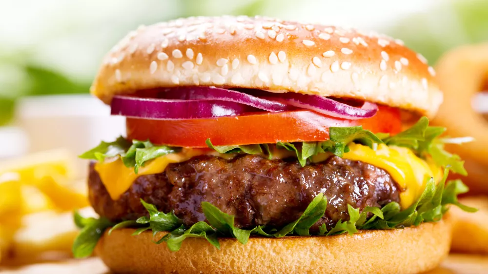 hamburger with fries on wooden table