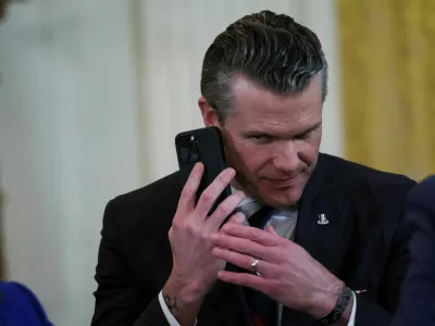 FILE PHOTO: U.S. Defense Secretary Pete Hegseth uses a phone as he attends a joint press conference of U.S. President Donald Trump and Israeli Prime Minister Benjamin Netanyahu in the East Room at the White House in Washington, U.S., February 4, 2025. REUTERS/Leah Millis/File Photo