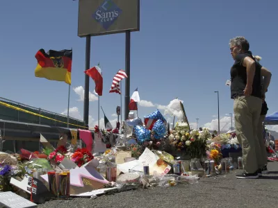 FILE - In this Aug. 12, 2019 photo, mourners visit the makeshift memorial near the Walmart in El Paso, Texas. (AP Photo/Cedar Attanasio, File)