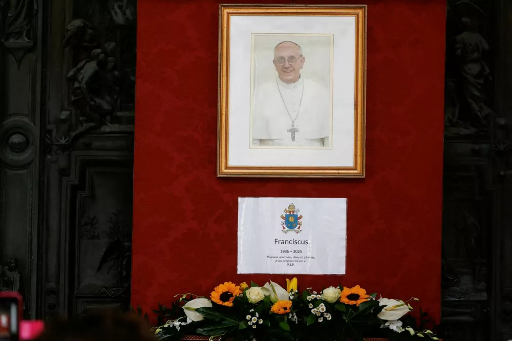 An image of Pope Francis and information including his year of death and birth are displayed, at the Basilica of Santa Maria Maggiore, in Rome, Italy, April 21, 2025. REUTERS/Vincenzo Livieri