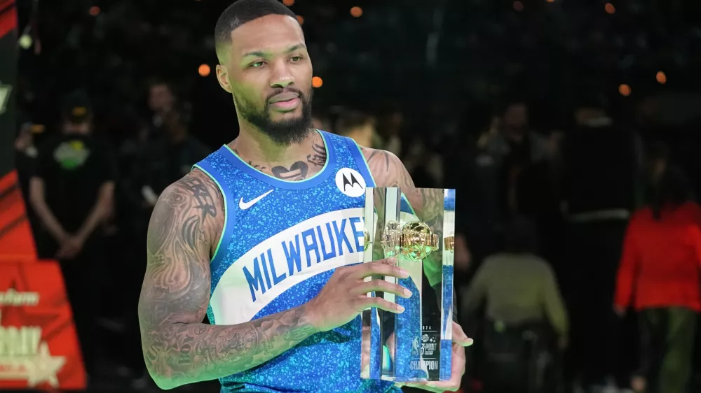 Milwaukee Bucks' Damian Lillard holds the trophy after winning the 3-point contest at the NBA basketball All-Star weekend, Saturday, Feb. 17, 2024, in Indianapolis. (AP Photo/Darron Cummings)