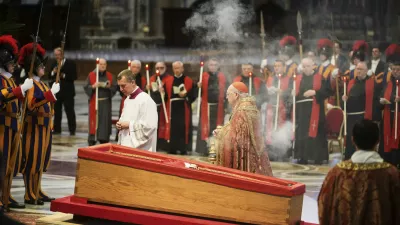 Cardinal Camerlengo Kevin Joseph Farrell, center right, spreads incense around the body of Pope Francis inside St. Peter's Basilica at the Vatican, Wednesday, April 23, 2025, where he will lie in state for three days. (AP Photo/Alessandra Tarantino)