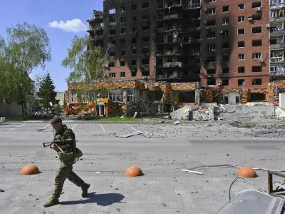 A Ukrainian soldier walks past damaged buildings in central Pokrovsk, the site of the heaviest battles with the Russian troops in the Donetsk region, Ukraine, Wednesday, April 23, 2025. (AP Photo/Michael Shtekel)