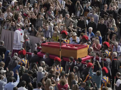 The body of Pope Francis is carried through St. Peter's Square to St. Peter's Basilica at the Vatican, Wednesday, April 23, 2025, where he will lie in state for three days. (AP Photo/Markus Schreiber)