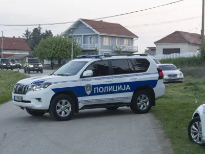 A police vehicle blocks the entrance to the village of Dubona, some 40 kilometers south of Belgrade, Serbia, Friday, May 5, 2023. A shooter killed multiple people and wounded more in a drive-by attack late Thursday in Serbia's second such mass killing in two days, state television reported. (AP Photo/Marko Drobnjakovic)