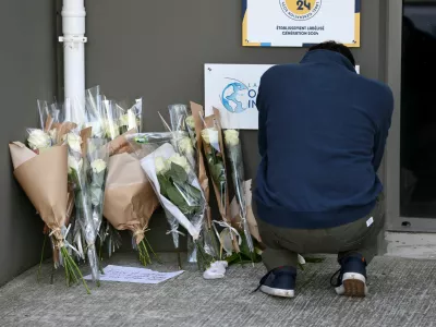 A man pays his respect next to flowers in front of the Notre-Dame-de-Toutes-Aides private school the day after one high school student was killed and three others injured in a stabbing attack by a 15-year-old boy, in Nantes, France, April 25, 2025. REUTERS/Stephane Mahe