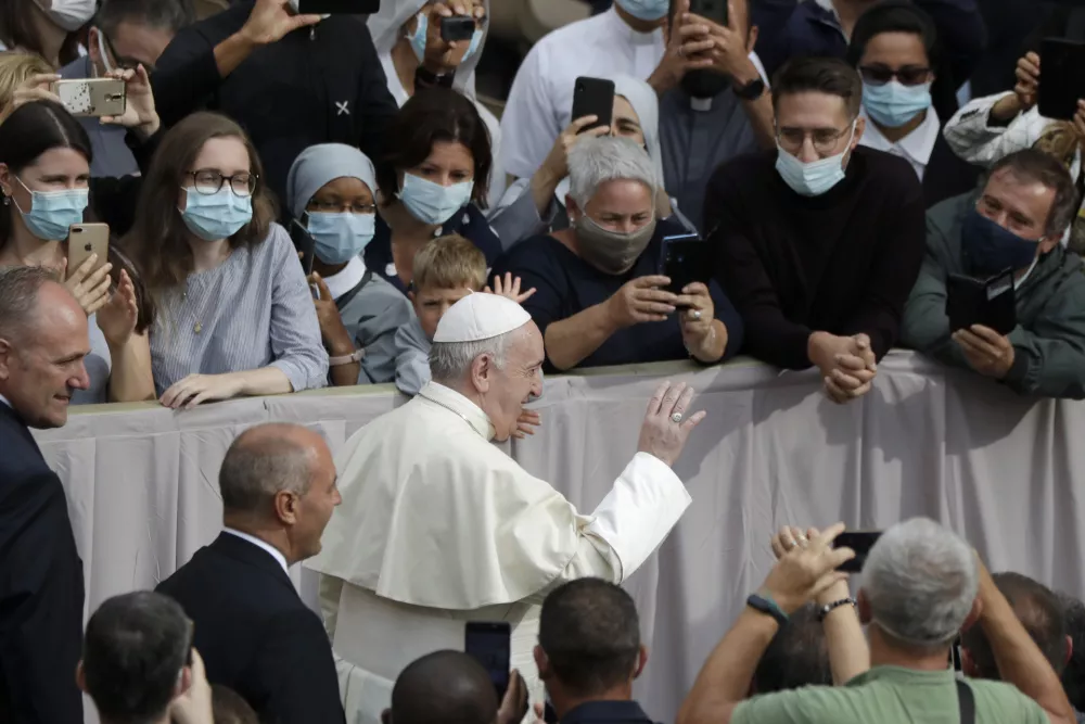 People wear face masks to prevent the spread of COVID-19 while Pope Francis waves as he arrives for his first general audience with faithful since February when the coronavirus outbreak broke out, in the San Damaso courtyard at the Vatican, Wednesday, Sept. 2, 2020. (AP Photo/Andrew Medichini) / Foto: Andrew Medichini