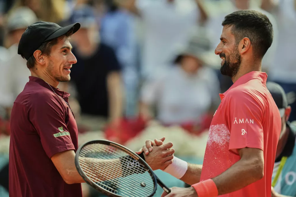 Novak Djokovic of Serbia, right, shakes hands with Matteo Arnaldi of Italy during the Madrid Open tennis tournament in Madrid, Spain, Saturday, April 26, 2025. (AP Photo/Manu Fernandez)