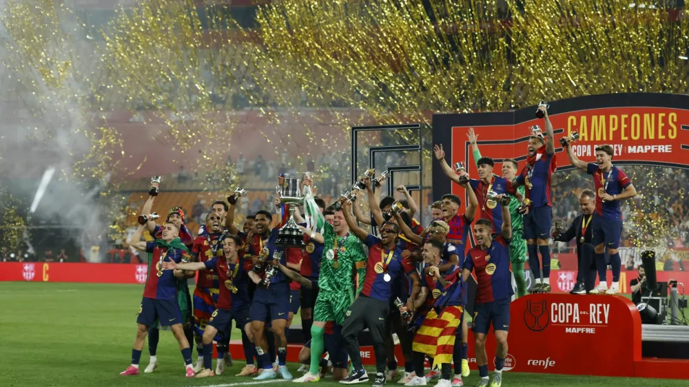 Soccer Football - Copa del Rey - Final - FC Barcelona v Real Madrid - Estadio de La Cartuja, Seville, Spain - April 26, 2025 FC Barcelona's Wojciech Szczesny and Ronald Araujo and teammates celebrate with the trophy after winning the Copa del Rey REUTERS/Marcelo Del Pozo