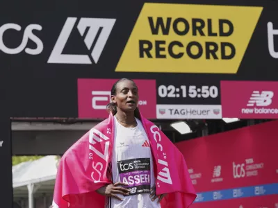 Tigst Assefa of Ethiopia poses for the cameras after setting a new women's only world record time and winning the women's race at the London Marathon, Sunday, April 27, 2025. (AP Photo/Alberto Pezzali)