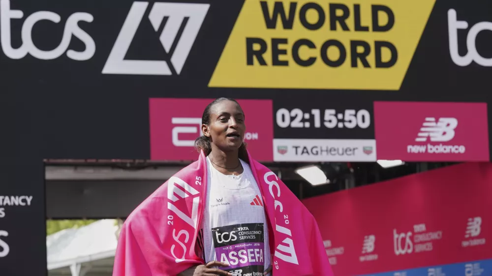 Tigst Assefa of Ethiopia poses for the cameras after setting a new women's only world record time and winning the women's race at the London Marathon, Sunday, April 27, 2025. (AP Photo/Alberto Pezzali)
