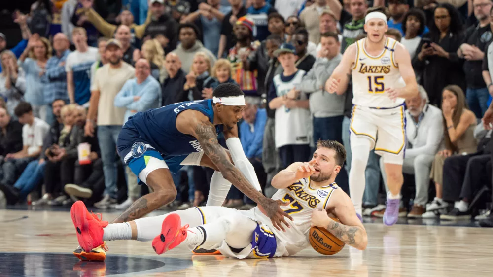 Apr 27, 2025; Minneapolis, Minnesota, USA; Los Angeles Lakers guard Luka Doncic (77) calls a timeout after stumbling on the defense of Minnesota Timberwolves forward Jaden McDaniels (3) in the fourth quarter during game four of first round for the 2025 NBA Playoffs at Target Center. Mandatory Credit: Matt Blewett-Imagn Images
