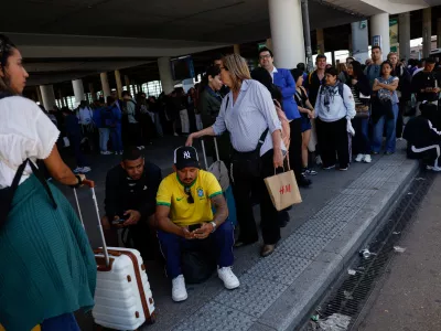 Travellers wait outside Atocha train station with their luggage after it was closed due to a power outage in Madrid, Spain, April 28, 2025. REUTERS/Susana Vera