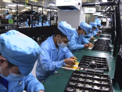 In this Feb. 13, 2020, photo released by Xinhua News Agency, workers wearing masks labor at a factory for Chinese telecommunications company OPPO in Dongguan, in southern China's Guangdong Province. Factories in China, struggling to reopen after the coronavirus shut down the economy, face a new threat from U.S. anti-disease controls that might disrupt the flow of microchips and other components they need. For most people, the new coronavirus causes only mild or moderate symptoms. For some it can cause more severe illness. (Chen Yuxuan/Xinhua via AP)