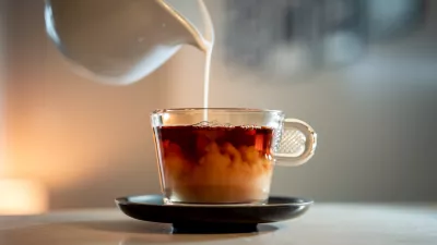 A close-up shot of a poring milk in a hot tea. / Foto: Wirestock