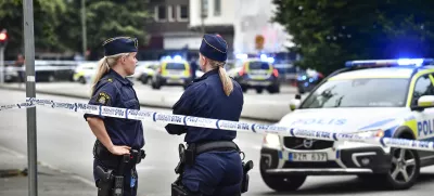 Police stand next to a cordon in central Malmo, southern Sweden, Monday, June 18, 2018. A Swedish newspaper is reporting that four people have injured in a shooting near a police station in the southern city of Malmo. Witnesses told newspaper Aftonbladet they heard what sounded like 15 to 20 shots about 6:15 p.m. in the city center.(Johan Nilsson/TT News Agency via AP)