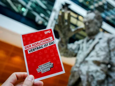 30 April 2025, Berlin: An advertising card with the inscription "The coalition agreement is here" can be seen at the Social Democratic Party of Germany (SPD) party headquarters, the Willy Brandt House, in front of the Willy Brandt statue. SPD has approved a coalition agreement with Friedrich Merz's conservative bloc in a members' ballot, paving the way for the new German government to take office next week. Photo: Kay Nietfeld/dpa