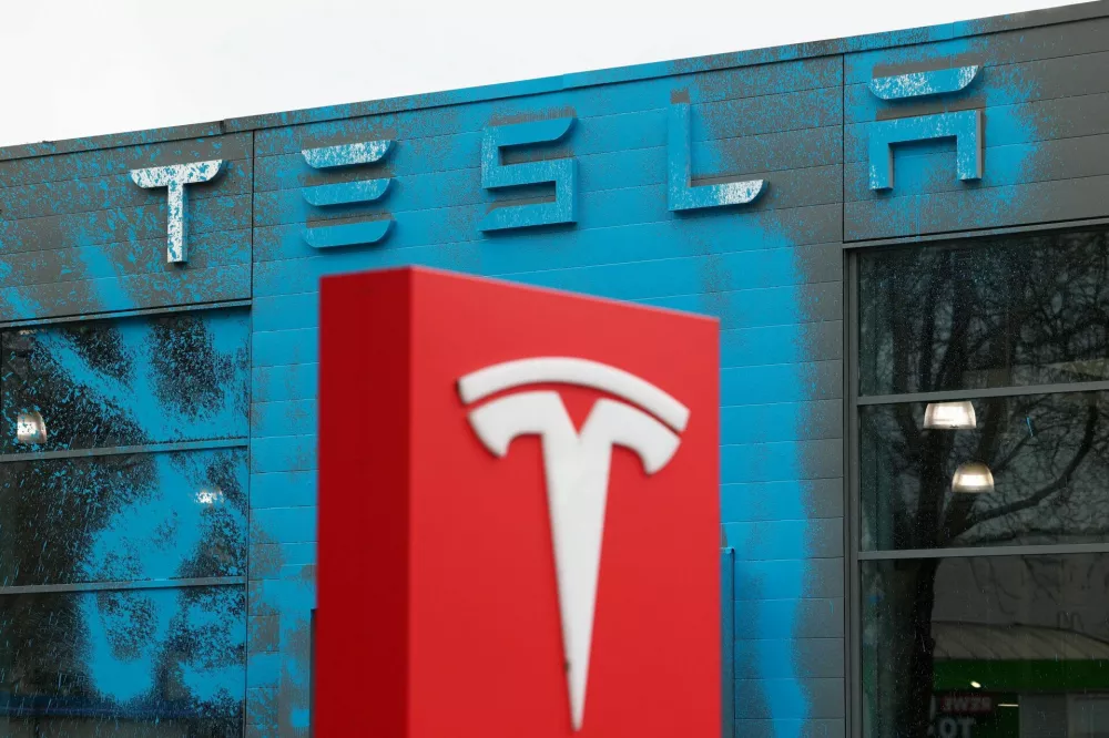 Blue paint covers the facade of a Tesla dealership after it was sprayed by supporters of New Generation (Neue Generation) during a protest against Elon Musk and against what organisers say is the destruction of democracy and the climate by the rich, in Berlin, Germany, March 31, 2025. REUTERS/Christian Mang   TPX IMAGES OF THE DAY