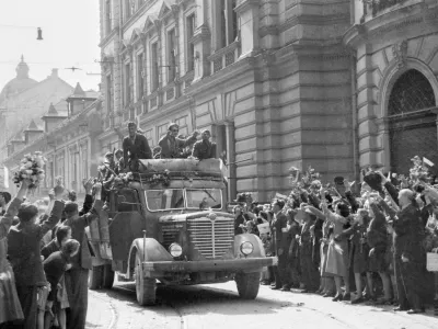 Množica s cvetjem pozdravlja partizansko vojsko, nekateri so se pripeljali s tovornjaki, Ljubljana, 9. maj 1945. Fotografija: Rudi Stopar, hrani Muzej novej&scaron;e in sodobne zgodovine SlovenijePOZOR, NI ZA PONOVNO OBJAVO BREZ DOVOLJENJA MNSZS!!!