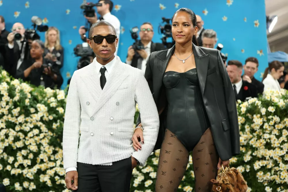 Pharrell Williams and Helen Lasichanh pose during the Met Gala, an annual fundraising gala held for the benefit of the Metropolitan Museum of Art's Costume Institute with this year's theme 'Superfine: Tailoring Black Style,' in New York City, New York, U.S., May 5, 2025. REUTERS/Mario Anzuoni