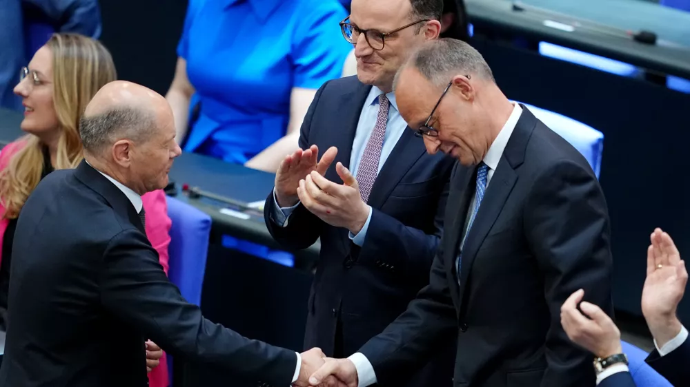 06 May 2025, Berlin: Acting German Chancellor Olaf Scholz shakes hands with Chancellor candidate Friedrich Merz during the second round of Chancellor election. Merz failed the first round of voting in the Bundestag. Photo: Kay Nietfeld/dpa