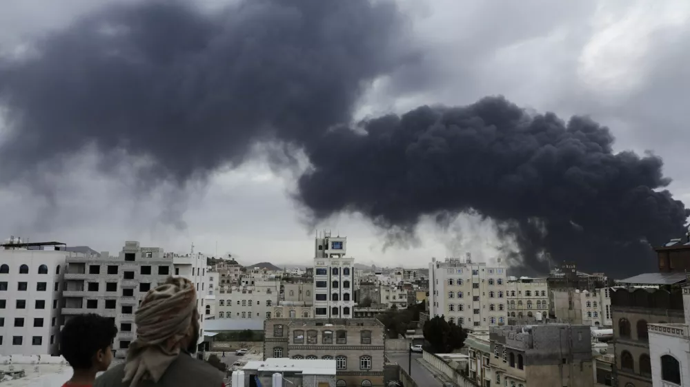Yemenis watch as smoke billows following Israeli airstrikes targeting a power plant and Sanaa Airport, in Sanaa, Yemen, Tuesday, May 6, 2025. (AP Photo/Osamah Abdulrahman)