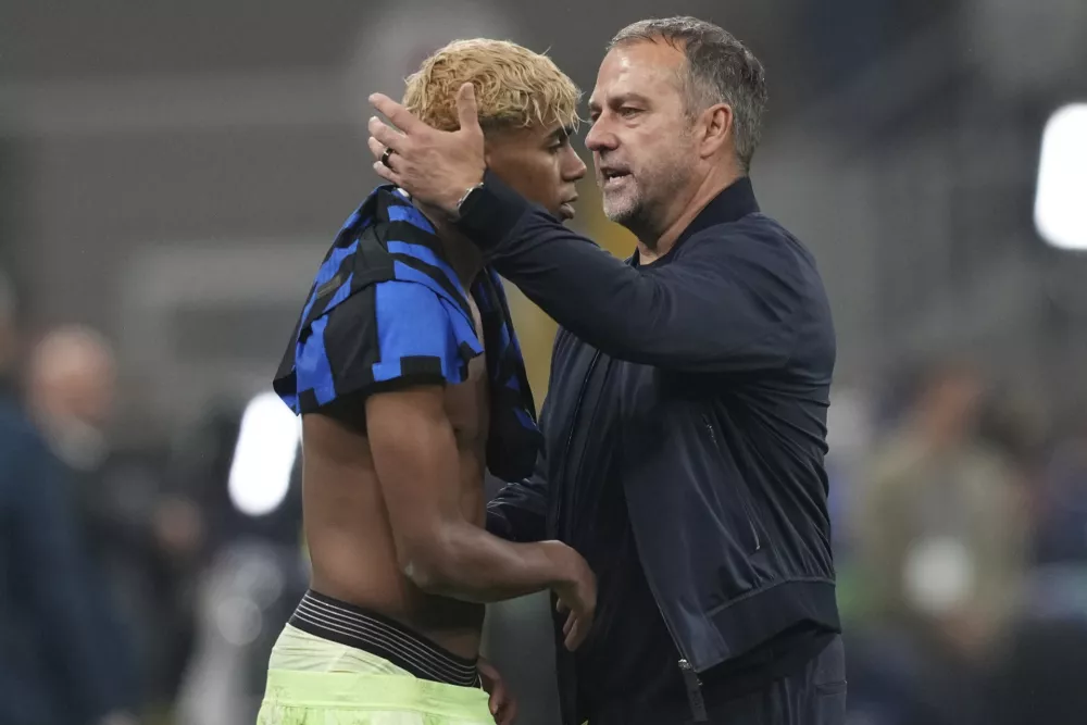 Barcelona's head coach Hansi Flick comforts Lamine Yamal after the Champions League semifinal second leg soccer match between Inter Milan and Barcelona at San Siro stadium in Milan, Italy, Tuesday, May 6, 2025. (AP Photo/Antonio Calanni)