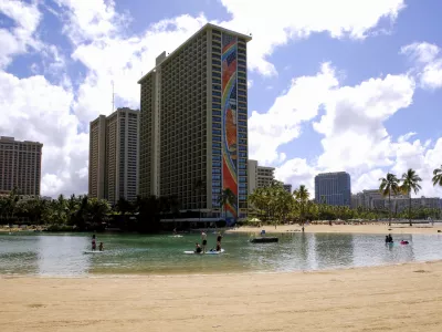 FILE - People swim in the lagoon in front of the Hilton Hawaiian Village resort in Honolulu on Saturday, Sept. 4, 2021. (AP Photo/Caleb Jones, File)