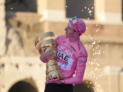 Tour of Italy winner Slovenia's Tadej Pogacar holds the trophy during the podium ceremony at the end of the 21st and last stage of the Giro D'Italia, cycling race, in Rome, Sunday, May 26, 2024. (AP Photo/Andrew Medichini)