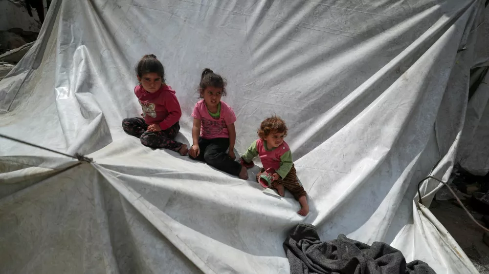 Palestinian children sit on a tent as they are displaced by the Israeli military offensive, in Gaza City, May 1, 2025. REUTERS/Mahmoud Issa   TPX IMAGES OF THE DAY