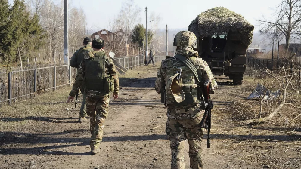 In this photo taken from video distributed by Russian Defense Ministry Press Service on Friday, March 14, 2025, Russian soldiers patrol an area in the Kursk region of Russia after it was taken over by Russian troops. (Russian Defense Ministry Press Service via AP)