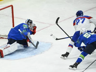 Slovakia's Sebastian Cederle (27) scores the opening goal at Slovenia's goalkeeper Matija Pintaric, left, during a Group A match between Slovakia and Slovenia at the hockey world championships at Avicii Arena in Stockholm, Sweden Sunday, May 11, 2025. (Fredrik Sandberg/TT News Agency via AP)