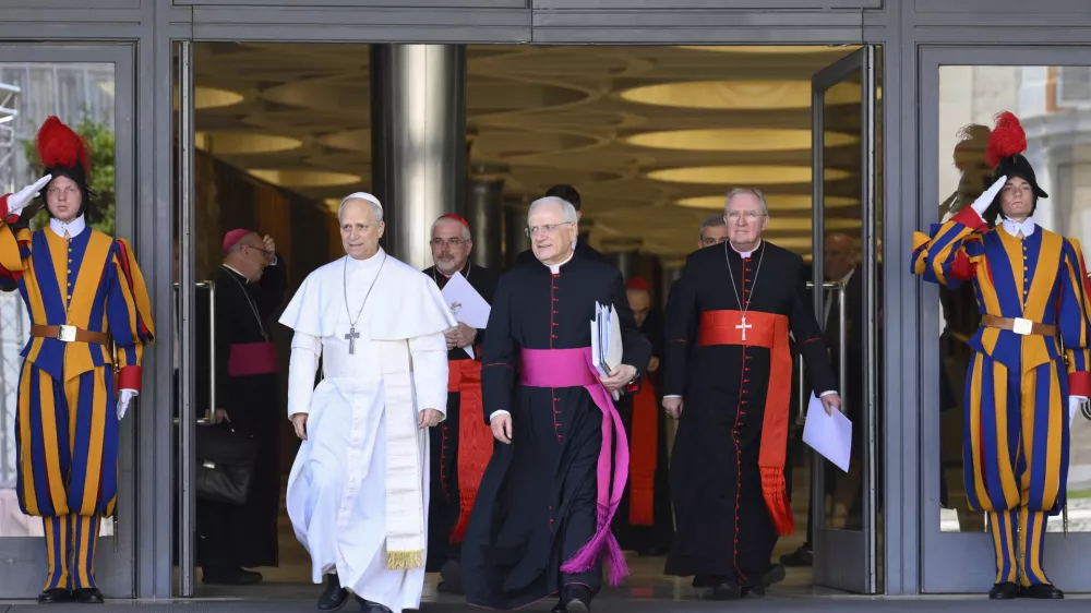 Pope Leo XIV, left, is flanked by Monsignor Leonardo Sapienza, second from left, after his meeting with the College of Cardinals in the New Synod Hall at the Vatican, Saturday, May 10, 2025. (Vatican Media via AP)