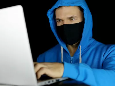 Mo&scaron;ki za računalnikom z masko na obrazu