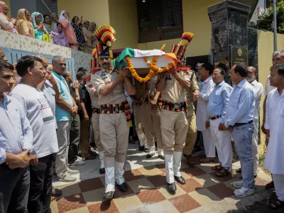 Policemen carry the body of Raj Kumar Thapa, a senior government official who was killed in a cross-border shelling between India and Pakistan, as relatives and neighbours mourn during his funeral in Roop Nagar, Jammu May 11, 2025. REUTERS/Adnan Abidi