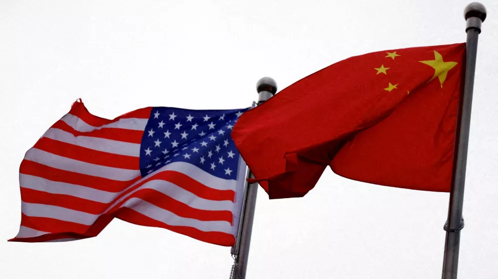 FILE PHOTO: Chinese and U.S. flags flutter outside the building of an American company in Beijing, China April 8, 2025. REUTERS/Tingshu Wang/File Photo
