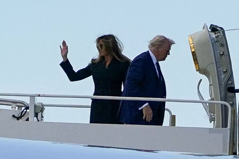 U.S. first lady Melania Trump waves next to President Donald Trump as they board Air Force One at Fiumicino Airport, while they leave after attending the funeral Mass of Pope Francis, near Rome, Italy, April 26, 2025. REUTERS/Nathan Howard