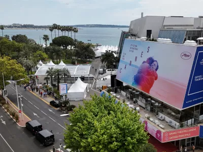 A drone view shows a giant canvas of one of the official double poster featuring a joint tribute to the two actors Anouk Aimee and Jean-Louis Trintignant in the film "A Man and a Woman" (Un homme et une femme) on the Festival Palace, ahead of the opening ceremony of the 78th Cannes Film Festival in Cannes, France, May 11, 2025. REUTERS/Sarah Meyssonnier