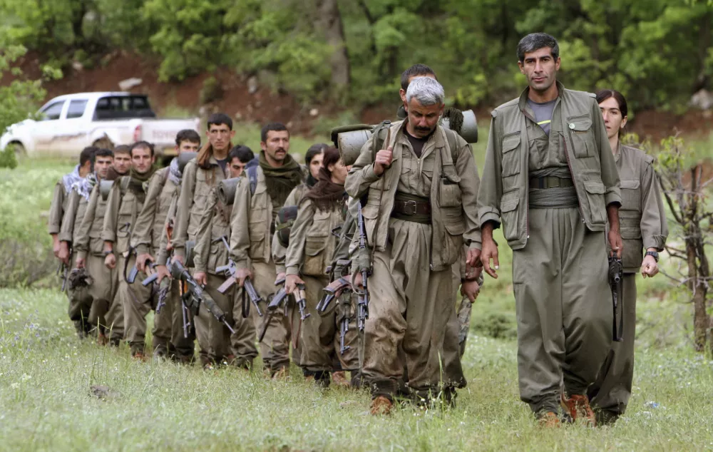 FILE - A group of armed Kurdish fighters from the Kurdistan Workers Party (PKK) enter northern Iraq in the Heror area, northeast of Dahuk, 260 miles (430 kilometers) northwest of Baghdad, Iraq, May 14, 2013. (AP Photo/Ceerwan Aziz, File)